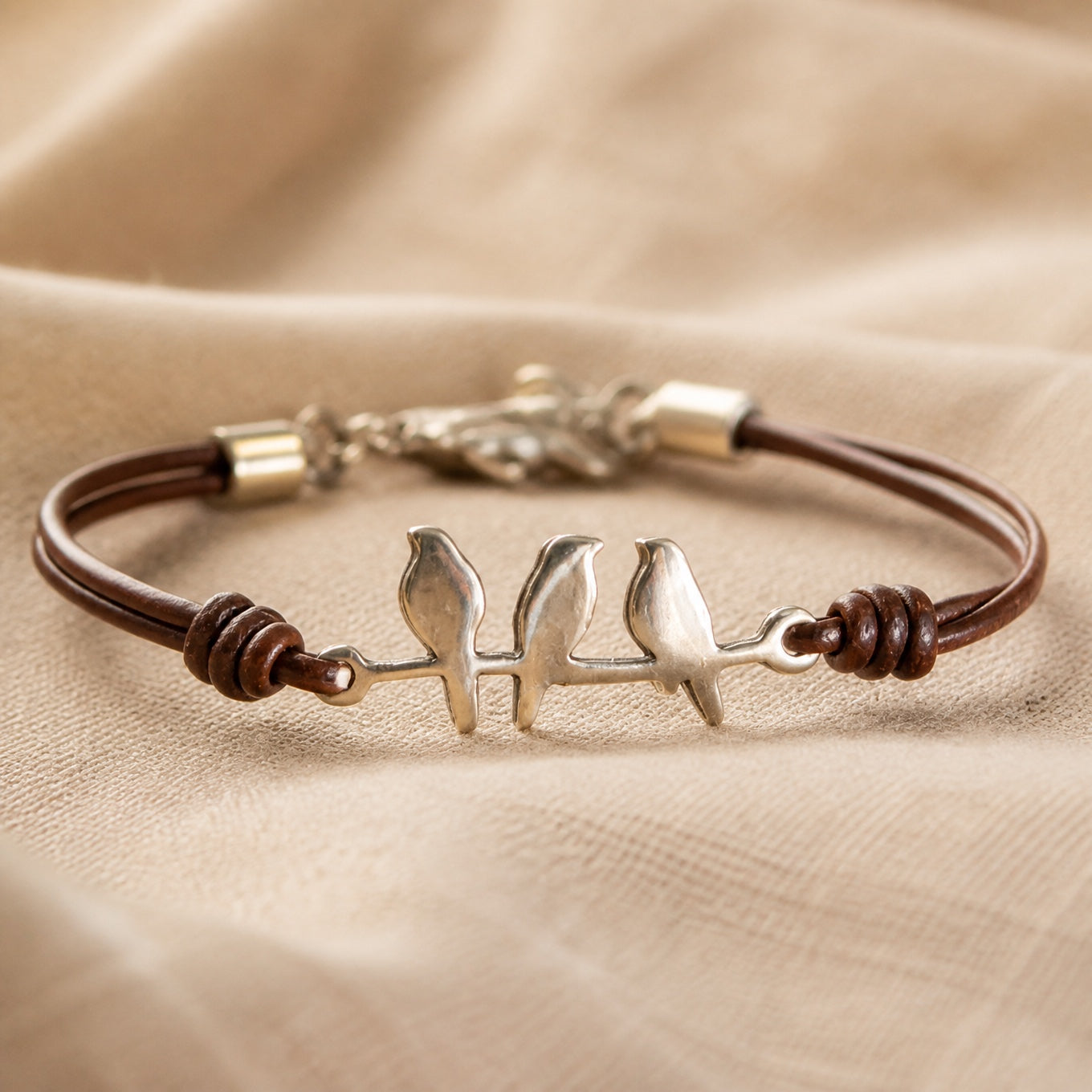 Pulsera de cuero con tres aves plateadas