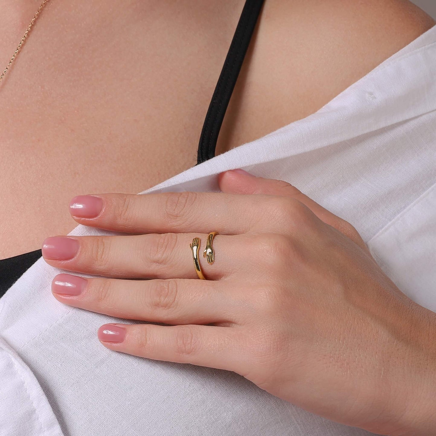 Anillo abrazo dorado en la mano